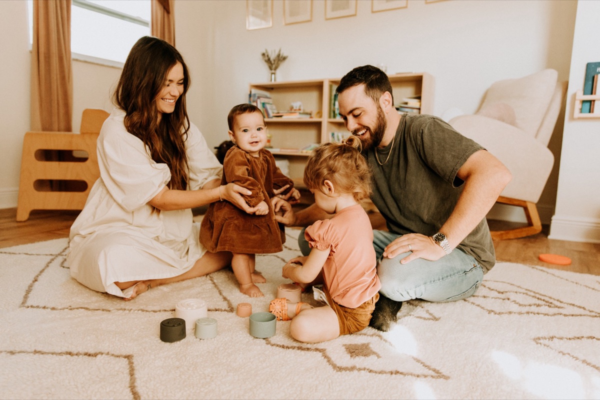 Aaron and his family playing on the living room rug